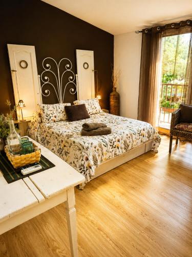 a bedroom with a bed and a table in it at Apartamentos Casas Rurales "Paraje San Blas" TR-BA-00166 in Alburquerque