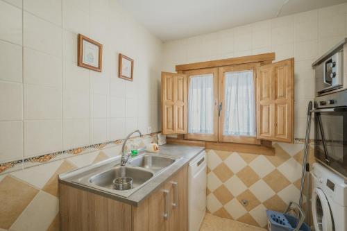 a small kitchen with a sink and a microwave at La Casa De La Golondrina in Pedro Bernardo