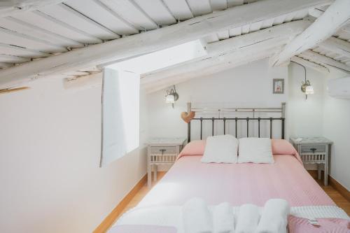 a bedroom with a pink bed with two white pillows at La Casa De La Golondrina in Pedro Bernardo
