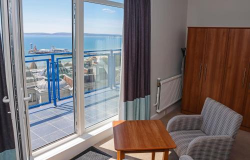a room with a balcony with a view of the ocean at Marsham Court Hotel in Bournemouth