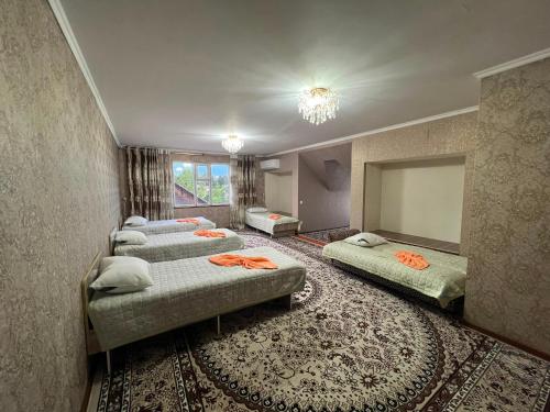 a group of four beds in a room at Olzho Guest House in Karakol