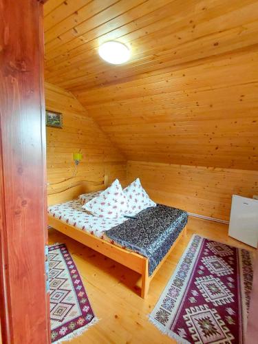 a room with a bed in a wooden cabin at Cabanutele Geo in Lacu Rosu