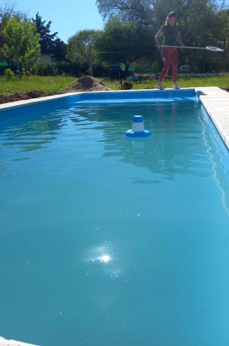 a woman is playing in a blue pool with a paddle at El Rancho Oliva in Molinari