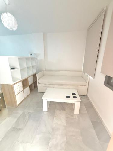 a small room with a white table and shelves at Piso en Barbate 2 dormitorios y piscina comunitaria in Barbate