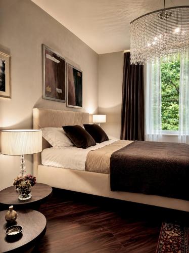 a bedroom with a large bed and a chandelier at Villa Nuvola Suites in Fiorano Modenese