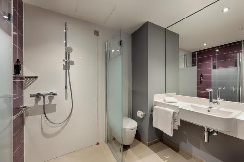a bathroom with a shower and a toilet and a sink at Premier Inn Essen City Centre in Essen