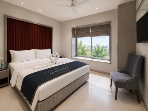 a bedroom with a large bed and a chair at The Bay Suites - MMR in New Town