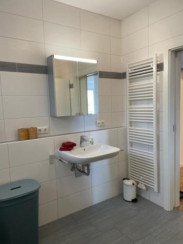 a white bathroom with a sink and a mirror at Ferienwohnung Seeblick in Pleinfeld