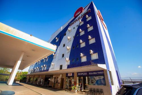 a large blue building with a sign on it at Hotel Caminho do Rosário in Aparecida