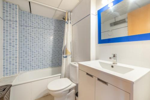 a bathroom with a white toilet and a sink at Planta baja Marita in Deltebre