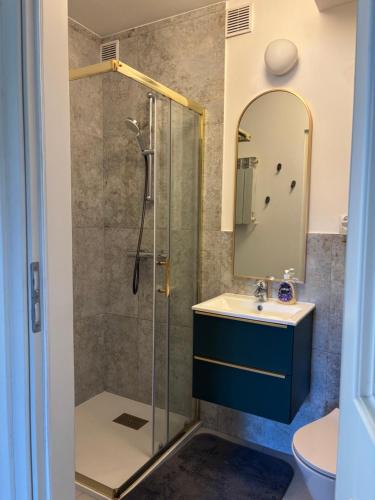 a bathroom with a shower and a sink and a mirror at Apartament centrum Szczytno Mazury in Szczytno
