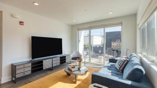 a living room with a blue couch and a flat screen tv at The Carter by AvantStay in Nashville