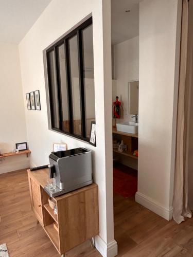 ein Wohnzimmer mit einem Fernseher auf einem Holzständer in der Unterkunft Ker Amice , une parenthèse de calme près de Bordeaux , 3 chambres avec Spa Privatif in Saint-Loubès