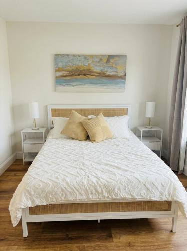 a bedroom with a white bed with two night stands at New Cape Cod Condo Near Beaches in Brewster