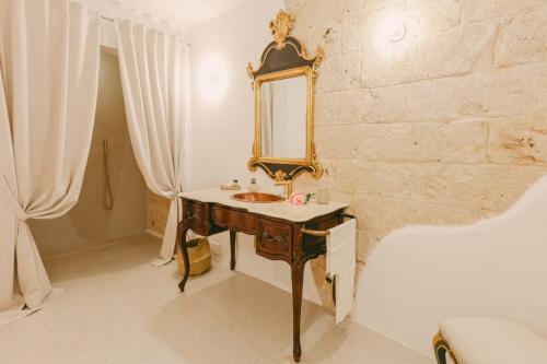 a bathroom with a sink and a mirror on a wall at Treviè Suite - Torre San Giovanni in Fontanelle