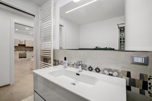a white bathroom with a sink and a kitchen at Sea House Superior in Pietra Ligure