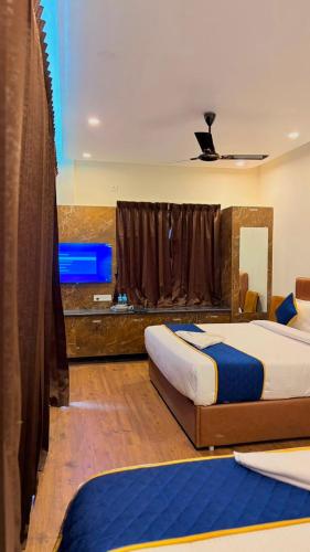 a bedroom with two beds and a large window at Hotel Vakula Matha Grand in Tirupati