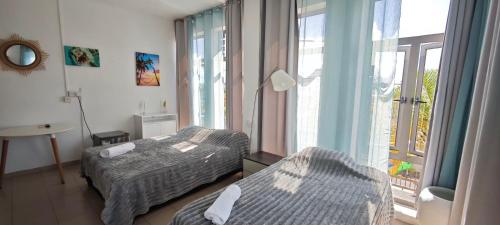 a hotel room with two beds and a window at Mountview Tourist Residence in Quatre Bornes