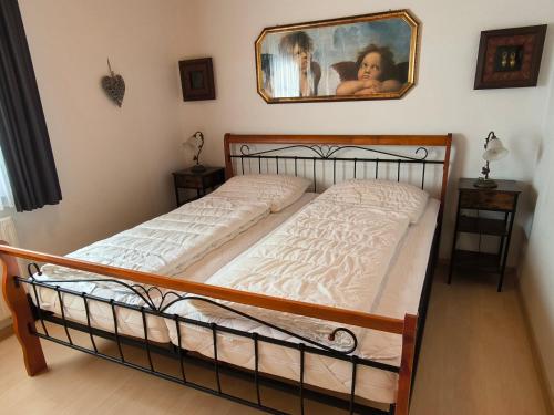 a bed in a room with a picture on the wall at Obergeschoss Bungalow 47 in der Ferienanlage RHÖN RESIDENCE in Dipperz