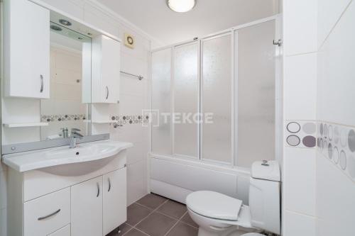 a white bathroom with a toilet and a sink at TEKCE Yeşilüzümlü Villa No 17 in Uzumlu