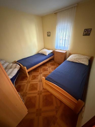 a bedroom with two beds and a wooden floor at Villa Oliva Vir in Vir
