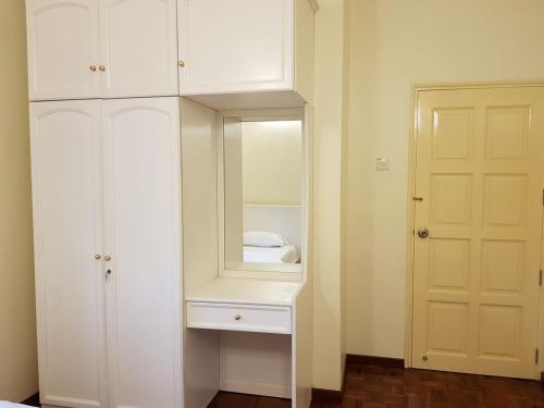 a white cabinet with a mirror in a room at Cozy Modern Quiet Garden in Tanah Rata