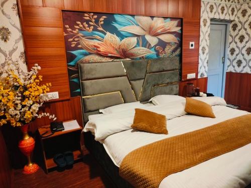 a bedroom with a bed and a painting on the wall at Basera Residency Shalimar in Bāgh Chandpura