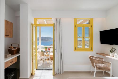 a room with a door open to a dining room with a view at Asterry Suites in Kimolos