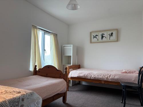a bedroom with two beds and a window at Diamond View House in Letterfrack