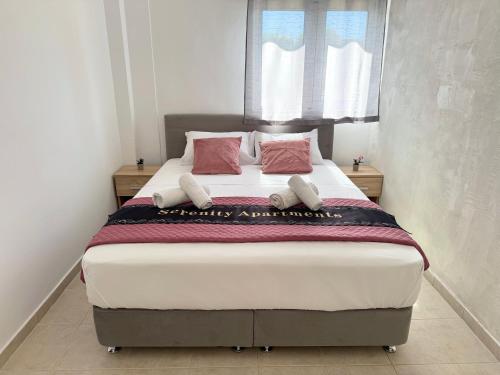 a bedroom with a large bed with pink pillows at Serenity home in Souda