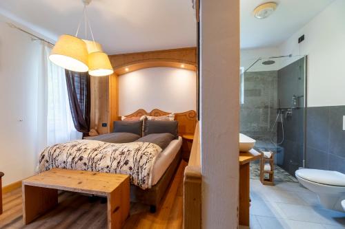 a bedroom with a large bed and a bathroom at Rifugio Cereda in Fiera di Primiero