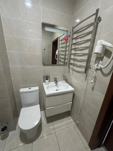 a bathroom with a white toilet and a sink at Готель Пісня Гір in Ralevka