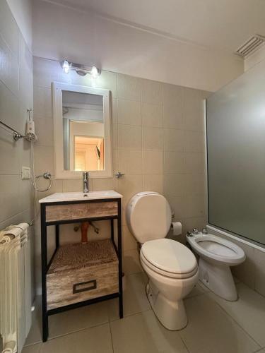 a bathroom with a toilet and a sink at Este Apart in Bahía Blanca