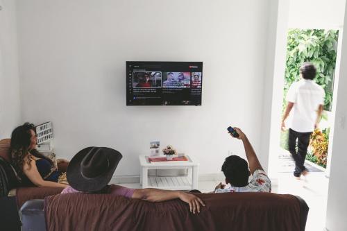 a group of people sitting on a couch in a living room at Casa Viveros cerca de jardines 3 recamaras albercas y 2 estacionamientos in Jiutepec