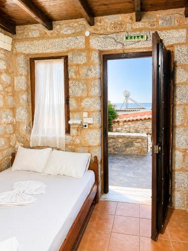 a bedroom with a bed and a window with a view at Lalloudes Hotel Mani in Éxo Nímfion