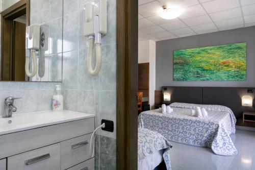 ein Krankenzimmer mit Bett und Waschbecken in der Unterkunft Hotel Côte D'Est in San Foca