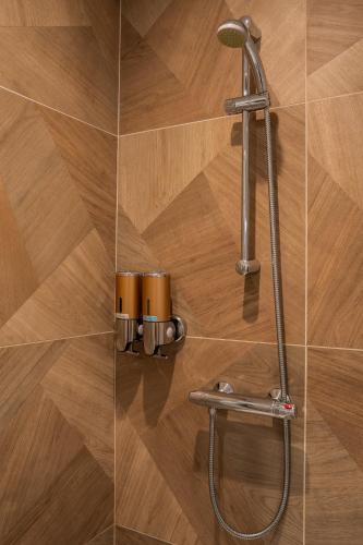 a shower with a hose attached to a wall at Appartement central - L'ouest in Tarare