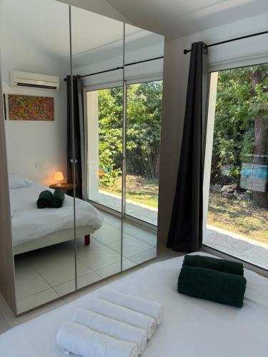 a bedroom with a mirror and a bed and a window at Guest house Maison d'invités in Le Rouret