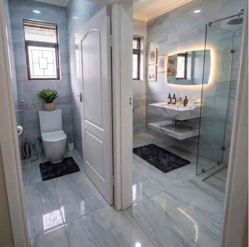 a bathroom with a shower and a toilet and a sink at Moxley Manor in Durban