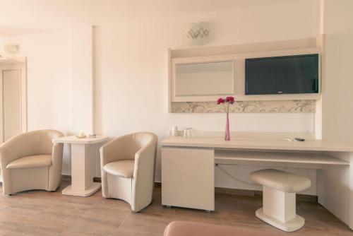 a white desk with two chairs and a vase with a flower at Complex Turistic Perla Venusului in Venus