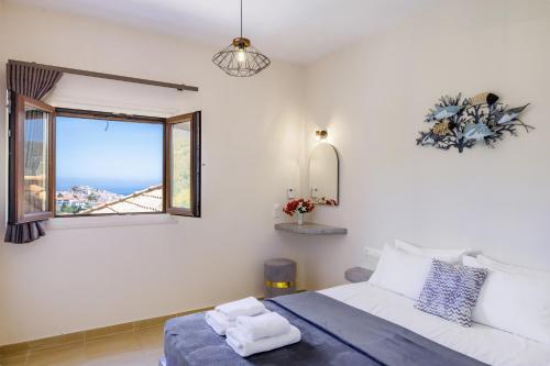 a bedroom with a large bed and a window at Villa Anatoli in Skopelos Town