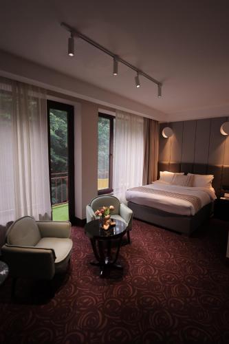 a hotel room with a bed and a table and chairs at Best Western Plus Paradise Hotel Dilijan in Dilijan