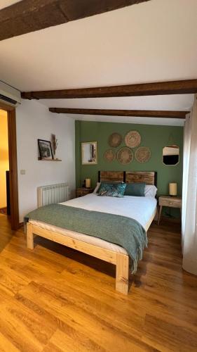 a bedroom with a large bed with green walls at Las Casitas de Martín in Candeleda