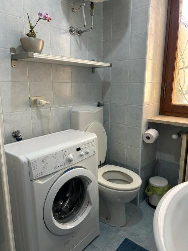 a bathroom with a washing machine and a toilet at Alpine penthouse, breathtaking views! in Bussoleno