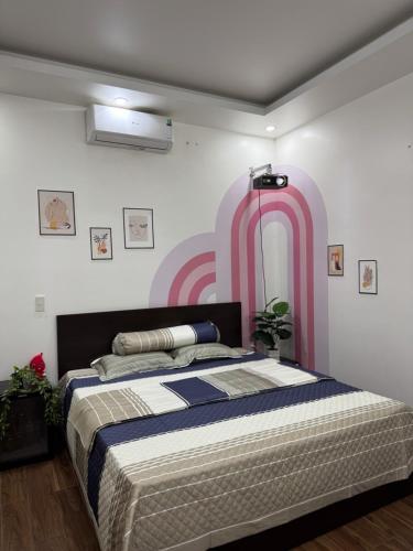 a bedroom with a large bed with a pink wall at 05 Homestay Cinema in An Khê