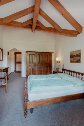 a bedroom with a large wooden bed in a room at Hotel Tiroler Adler in Lutago