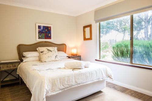 a bedroom with a bed and a large window at Bettenays Margaret River in Metricup