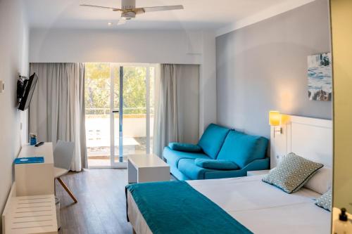 a hotel room with a bed and a couch at Hotel Pinos Playa in Cala Santanyi