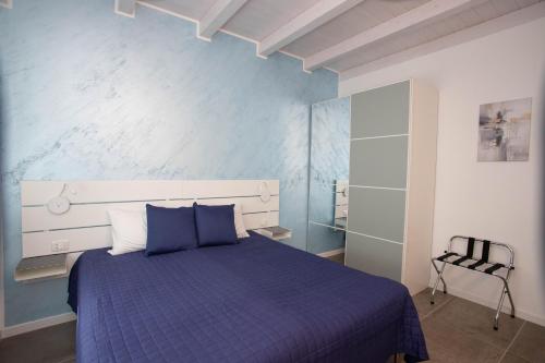 a bedroom with a blue bed and a chair at Casa Terry in Ronchi dei Legionari