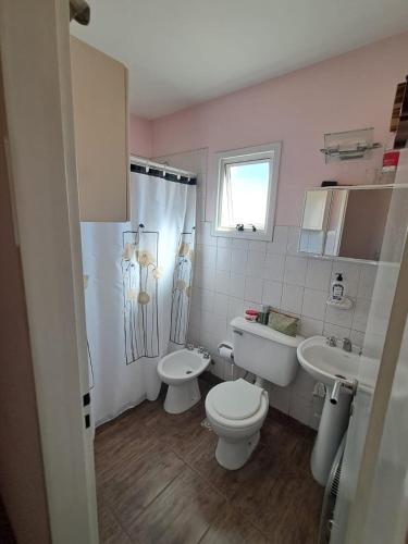a pink bathroom with a toilet and a sink at Habitación Privada en La Casa de Thor in Trelew